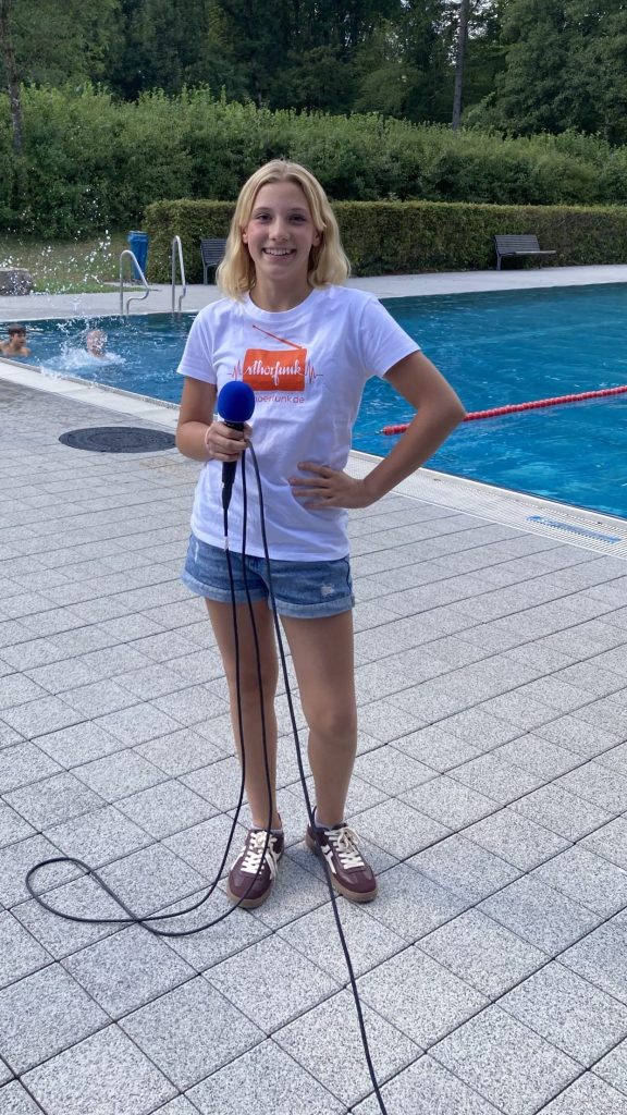 Luisa mit Mikrofon bei der Live-Sendung von Radio StHörfunk im Freibad Rieden